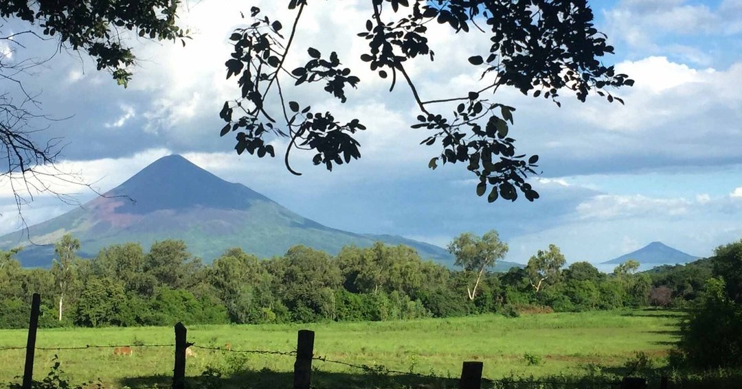 A volcanic peak framed by trees near El Tránsito, Nicaragua